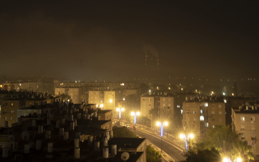 A dense cloud of smoke from the bombing of the Gaza Strip invades the Israeli border city of Ashkelon on the night of October 27, 2023 as battles between Israel and the Palestinian Hamas movement continue. The Israeli army on the evening of October 27 carried out bombings of "unprecedented" intensity since the start of the war in the north of the Gaza Strip, particularly in Gaza City, according to images from AFP and the Hamas movement. (Photo by Yuri CORTEZ / AFP)