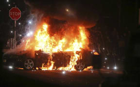 A car burns after petrol bombs were thrown at police in Creggan, Londonderry, in Northern Ireland, on April 18, 2019.