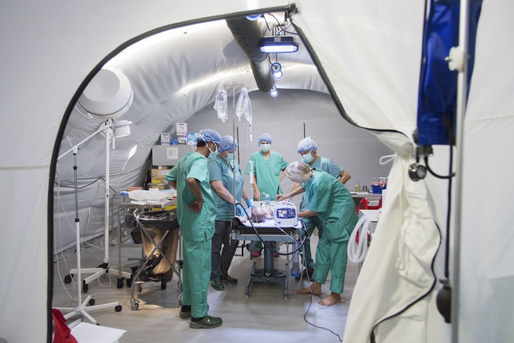 Red Cross staff operate on a baby boy in the field hospital.