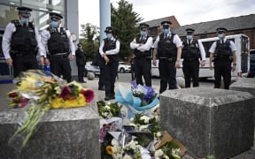 Police officers wearing protective face masks, pay their respects outside the Croydon Custody Centre in south London on 25 September 2020 following the shooting of a British police officer, reported to be a NZer by a 23-year-old man, being detained at the centre.