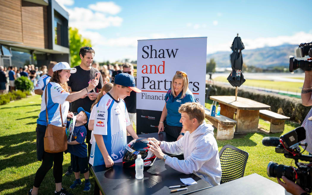 Liam Lawson speaking to people at the event.