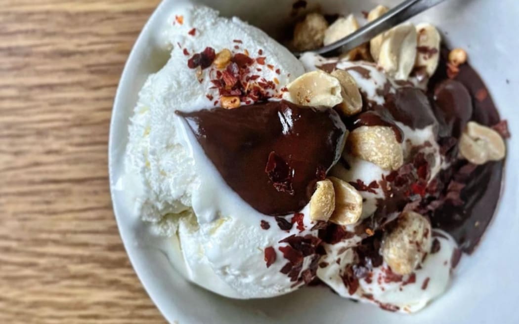 A bowl of Lucy Corry's Famous Vanilla Ice Cream With Chocolate Sauce and Spicy, Salty Nuts