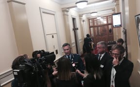 Police Commissioner Mike Bush is questioned by journalists outside a select committee room following the annual review of New Zealand Police.