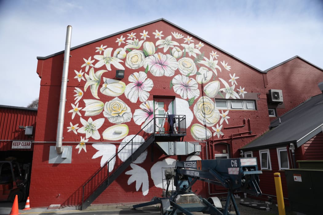 Artist Paul X Walsh has painted 51 flowers on the side of Pomeroys Inn in Christchurch as a mural for the victims of the March 15th Mosque Attack.