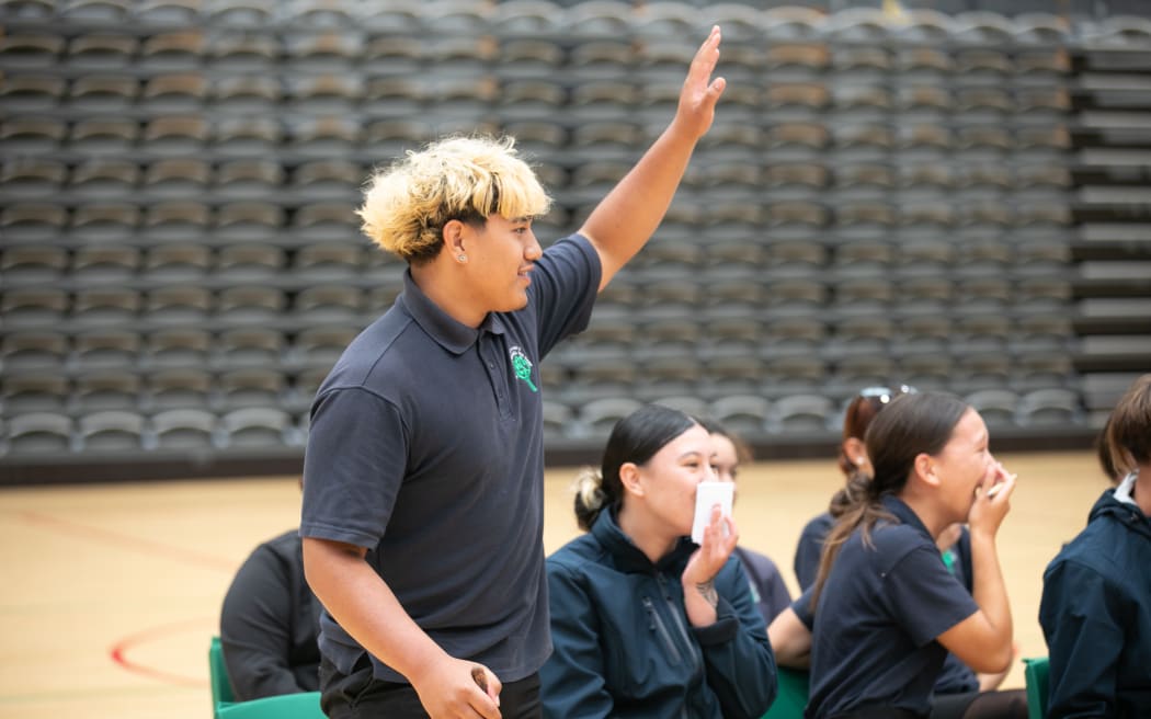 A student on the Government side of the mock debate stands to raise a point of order.