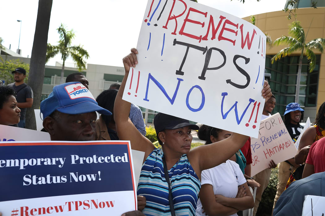 People protest the possibility that the Trump administration may overturn the Temporary Protected Status for Haitians in front of the U.S. Citizenship and Immigration Services office on May 13, 2017 in Miami, Florida.