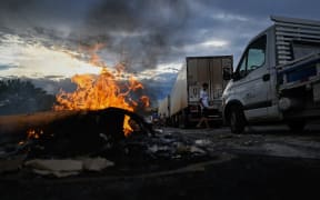 Supporters of President Jair Bolsonaro, mainly truck drivers, set a barrier on fire during a blockade on the Via Dutra BR-116 highway between Rio de Janeiro and Sao Paulo, in Volta Redonda, Rio de Janeiro state, Brazil, on October 31, 2022, as an apparent protest over Bolsonaro's defeat in the presidential run-off election. - Truckers and other protesters on Monday blocked some highways in Brazil in an apparent protest over the electoral defeat of Bolsonaro to leftist Luiz Inacio Lula da Silva, authorities said. (Photo by MAURO PIMENTEL / AFP)