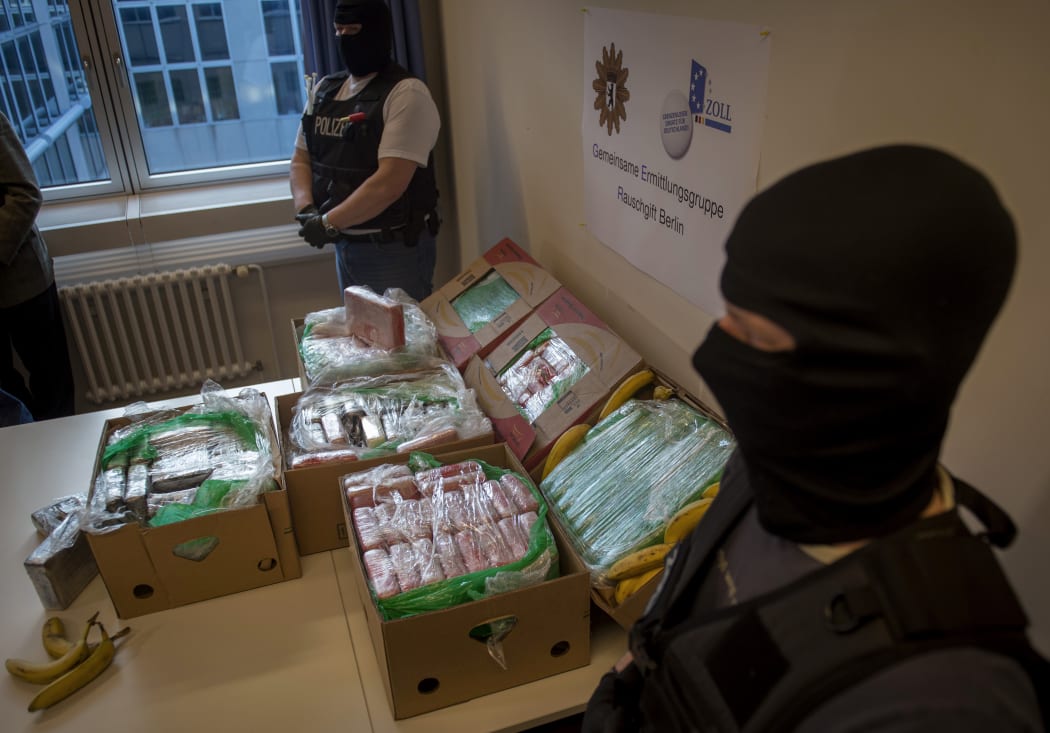 Police and custom officers guard the cocaine found crates of imported bananas.
