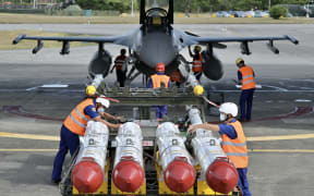 Air Force soldiers prepare to load US made Harpoon AGM-84 anti ship missiles in front of an F-16V fighter jet during a drill at Hualien Air Force base on 17 August, 2022.