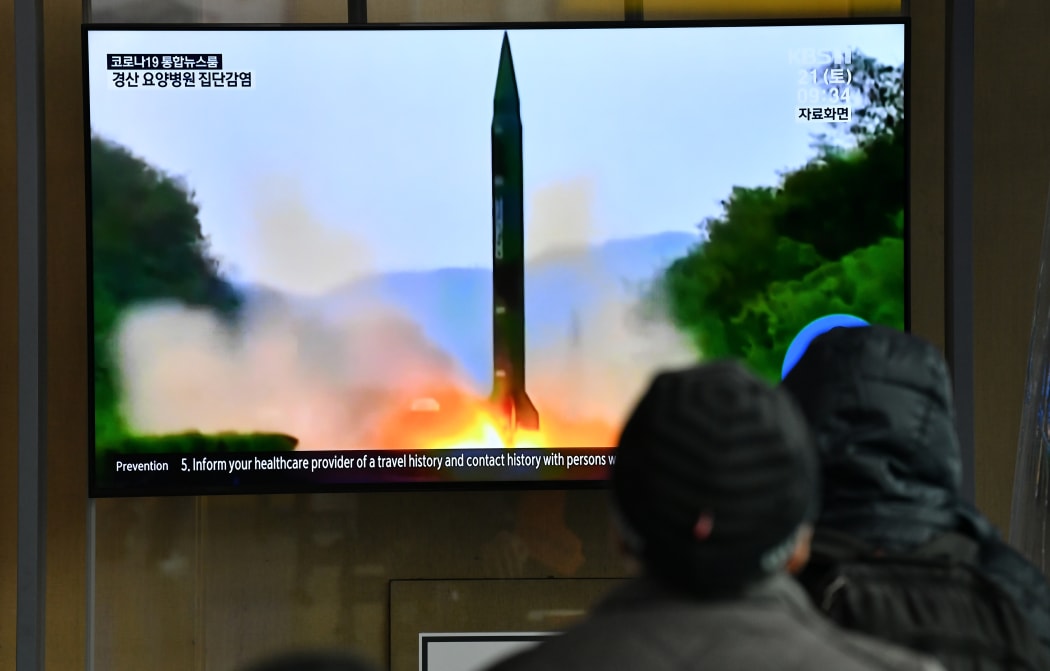People watch a television news broadcast showing a file image of a North Korean missile test, at a railway station in Seoul on 21 March 2020.