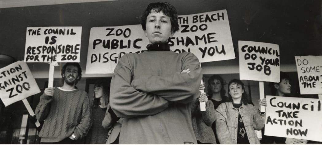 A group of protesters outside Christchurch City Council offices, opposing the North Beach Zoo and campaigning for the zoo's closure. Miss Kaye Fallows with other protesters holding placards behind her.