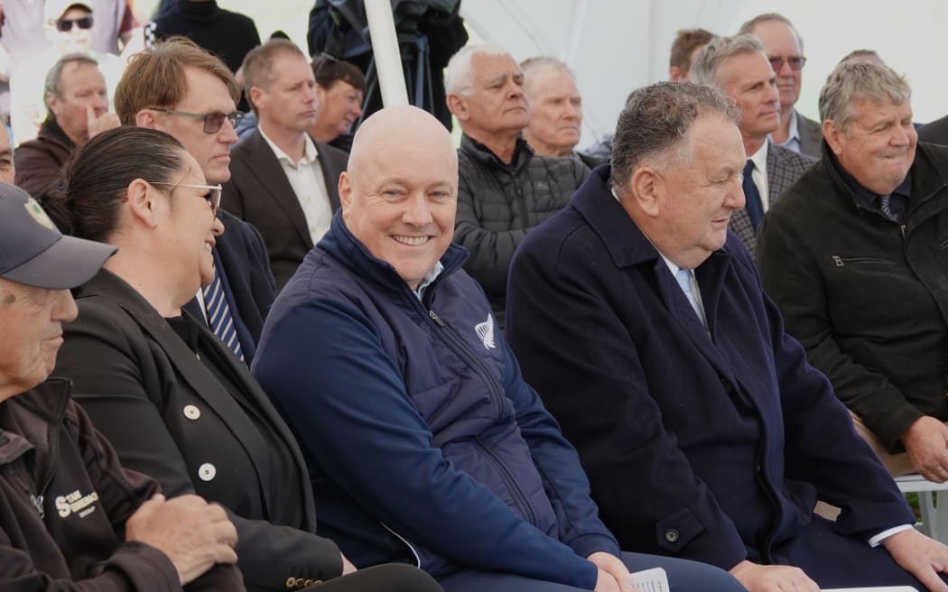 Prime Minister Christopher Luxon, flanked by Regional Development Minister Shane Jones and his wife Dot Jones, listens to the speeches.