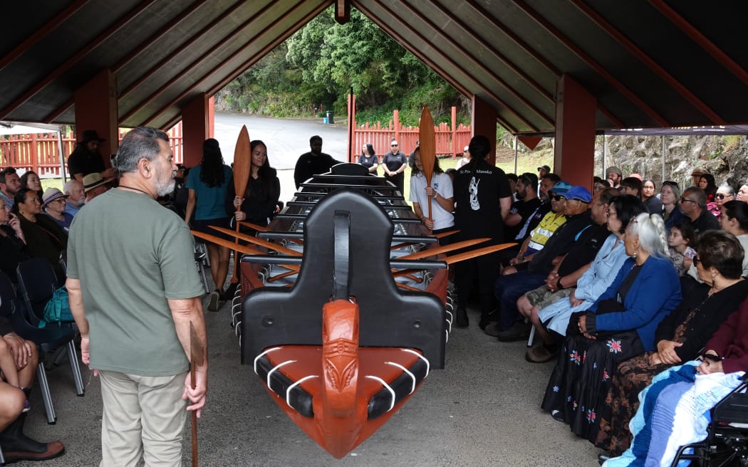 Freshly carved hoe [paddles] are placed in the waka as Ngāti Rēhia leader Kipa Munro conducts a blessing.