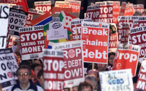 Banners are carried through the streets of London for the Jubilee 2000 March in aid of Western countries cancelling third world debt (London 2 December, 2000)