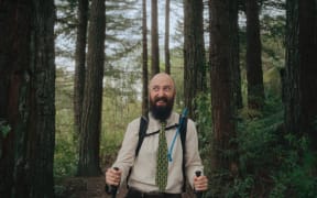 An actor walks through a forest in a still from a video promotional video for Manawatū