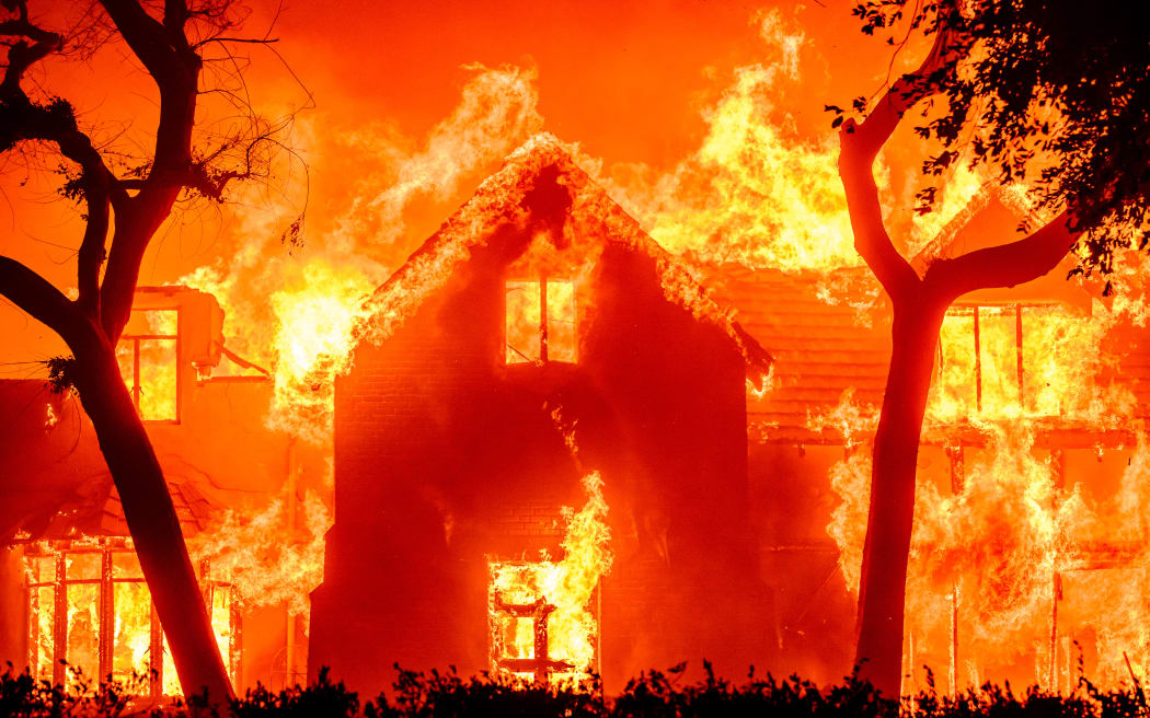 A home is engulfed in flames during the Eaton fire in the Altadena area of Los Angeles County, California on January 8, 2025. (Photo by JOSH EDELSON / AFP)