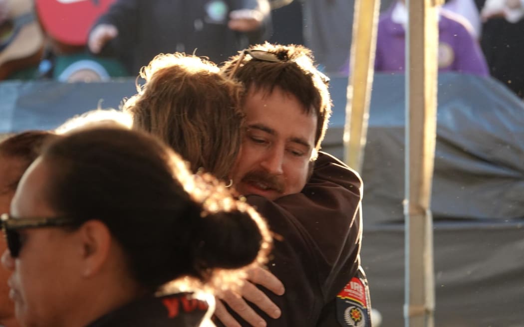 Two people embrace in a hug.