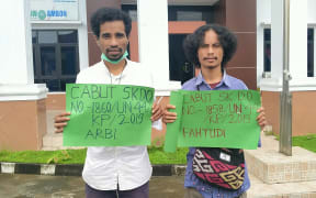 Two Indonesians protest the expulsion of four students from Khairun University for their role in a Papua human rights protest. The protest is outside the Ambon state administrative court where the students are challenging the expulsion.