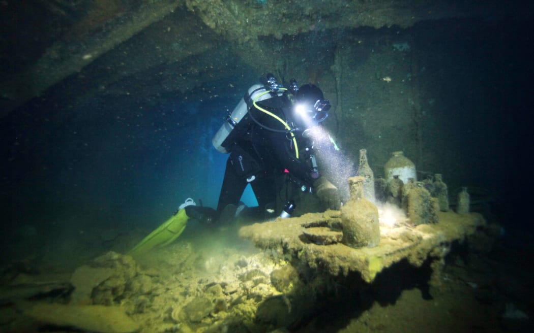 A diver searches for human remains in the Shinkoku Maru, an oil tanker, in the Federated States of Micronesia on Oct. 22, 2023. The Health, Labor and Welfare Ministry surveyed a Japanese tanker sunk during the Pacific War for human remains to be recovered, off Chuuk Lagoon, formerly Truk Lagoon. During the war, the Imperial Japanese Navy had a base on the atoll for its Combined Fleet. The base and Japanese ships were attacked by U.S. aircraft carriers on Feb. 17 and 18, 1944. Some 40 Japanese ships were sunk.Surveying of the ships was scheduled to take place from Oct. 21th to 24th. On 22nd, divers entered the Shinkoku Maru, an oil tanker lying 38 meters below the ocean’s surface. Divers shined lights into cabins and through gaps between steel frames, and confirmed there were human remains. They were set to recover the remains as soon as preparations were complete. During World War II, 2.4 million Japanese civilians and members of the military died abroad. The remains of 1.12 million people have not been...