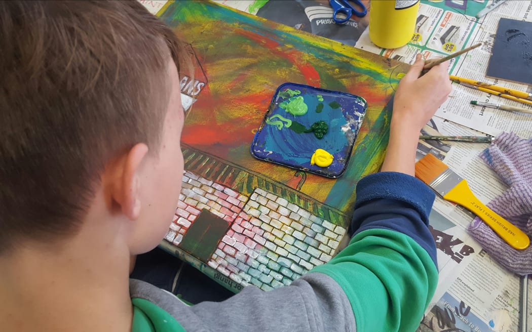 A He Kākano student works on his art.