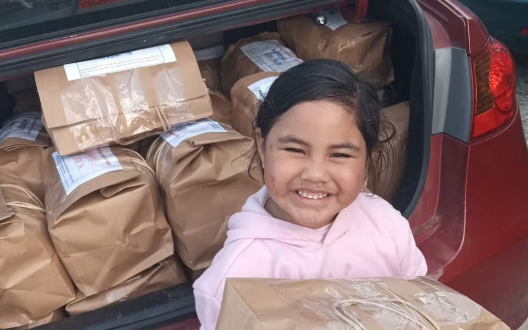 One of Deirdre Ahu's mokopuna helps deliver a food parcel to a family in need.