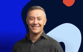 Host Nick Tipping stands in front of background of abstract shapes