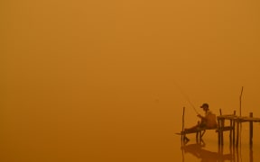 A resident fishes by the river in Palangkaraya city, Indonesia, one of worst-hit by haze in central Kalimantan province.