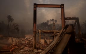 MALIBU, CALIFORNIA - JANUARY 8: Flames from the Palisades Fire burn a home on January 8, 2025 in Malibu, California. Fueled by intense Santa Ana Winds, the Palisades Fire has grown to over 2,900 acres and 30,000 people have been ordered to evacuate while a second major fire continues to burn near Eaton Canyon in Altadena.   Eric Thayer/Getty Images/AFP (Photo by Eric Thayer / GETTY IMAGES NORTH AMERICA / Getty Images via AFP)