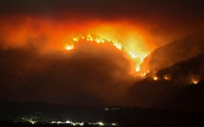 A picture taken from the village of Atajate shows the flames of a wildfire burning a forest area behind the village of Alpandeire on 12 September 12.