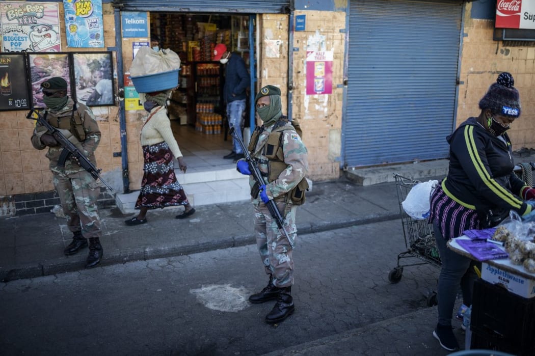 South African National Defence Force (SANDF) soldiers patrol among street vendors and food stalls at the Bara taxi rank in Soweto, Johannesburg, on June 1, 2020, during a joint patrol by the South African National Defence Force (SANDF) and the South African Police Service (SAPS).