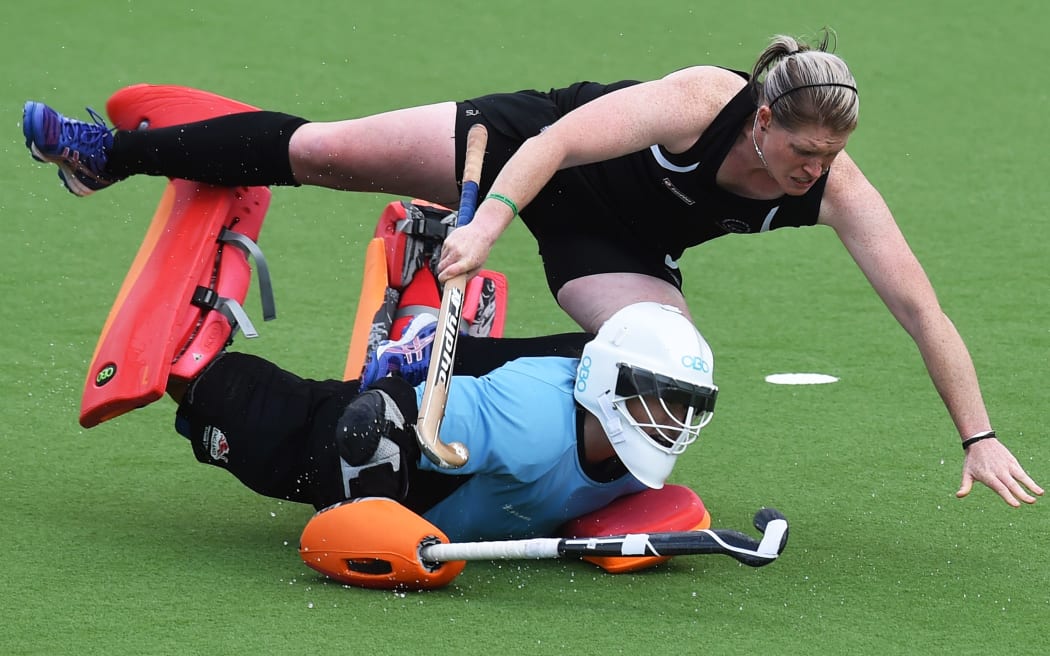 Katie Glynn trips over England Goalie Maddie Hinch during the Black Sticks' loss in the Glasgow semi-final.