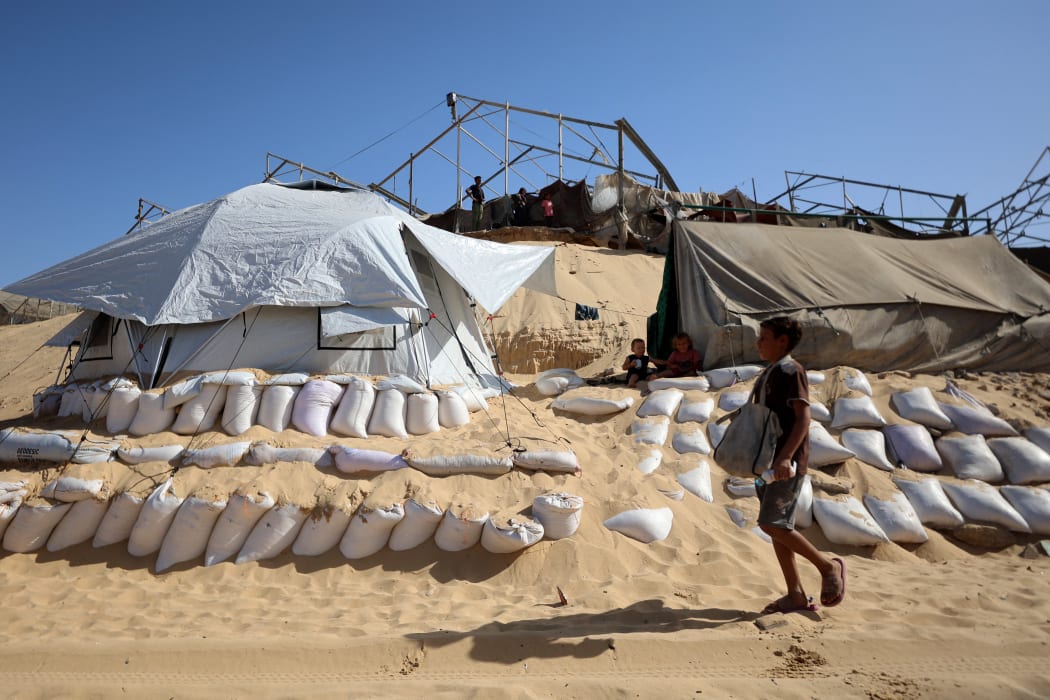 A child walks at a camp for displaced Palestinians set up near the beach in Khan Yunis in the southern Gaza Strip, on October 2, 2025, amid the ongoing conflict between Israel and the Palestinian militant group Hamas. (Photo by Omar AL-QATTAA / AFP)