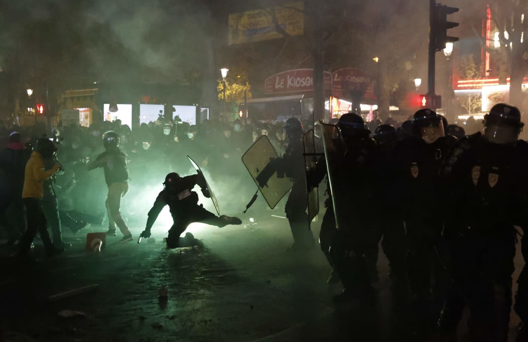 French riot police in Paris clash with protesters during a demonstration against the 'global security' draft law on 28 November.