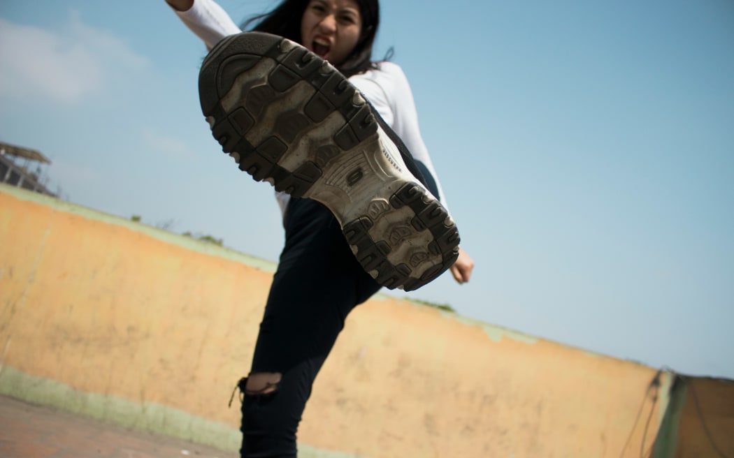 A woman kicks the camera with sneaker