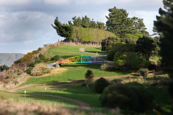 A rainbow-painted NZ railway bridge on The Moran's golf course, as seen from Transmission Gully.