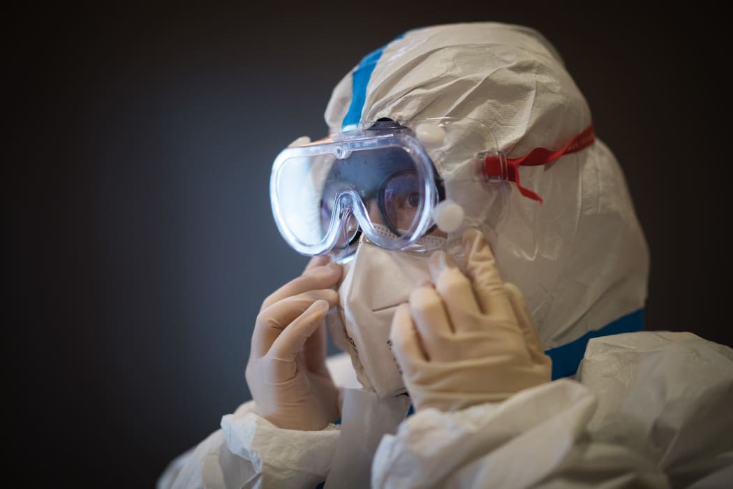 A member of the medical team of the Second Military Medical University puts on protective clothing at Hankou Hospital in Wuhan, central China's Hubei Province, on 27 January, 2020.