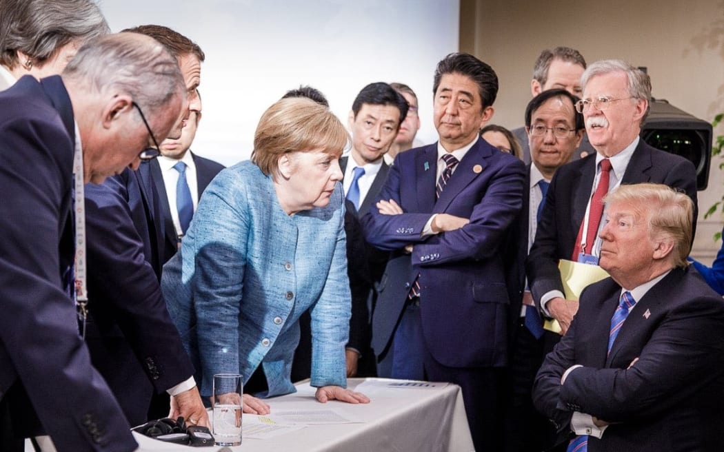 US President Donald Trump, right, talking with German Chancellor Angela Merkel and surrounded by other G7 leaders.