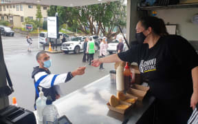 Ashlee Kemp of Chiwi Catering serves a customer.