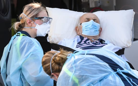 Ambulance officers transport a resident from the Epping Gardens aged care facility in the Melbourne suburb of Epping on July 29, 2020, as the city battles fresh outbreaks of the COVID-19 coronavirus.