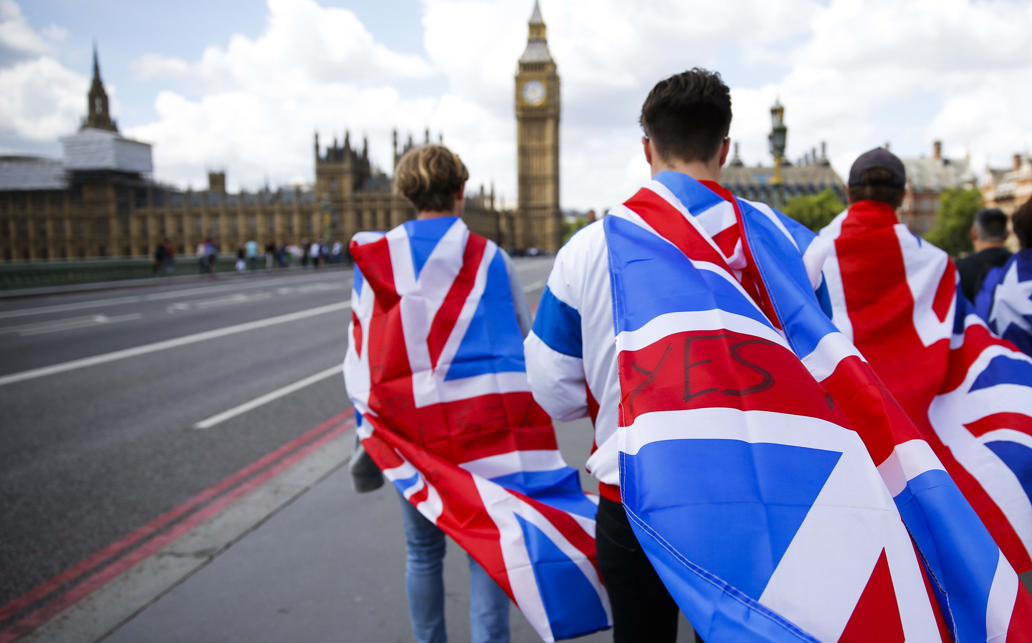 People walk over Westminster Bridge wrapped in Union flags.