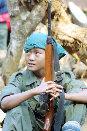 Karen National Union children soldier holds a gun  during the anniversary of the 53rd Karen National Resistance Day at Valay Kee base near Thailand-Myanmar border 31 January 2002. Karen are the largest ethnic minority in Myanmar and have been fighting for independence more than 50 years.