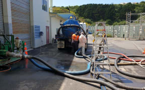 Sludge being pumped into trucks.