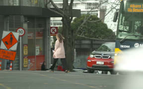RNZ reporter Louise Ternouth crosses the road in Auckland's CBD.