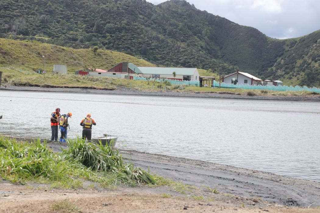 Search and rescue teams get in a dingy over the estuary at Marokopa early on Sunday afternoon, looking out at Mirumiru Marae.