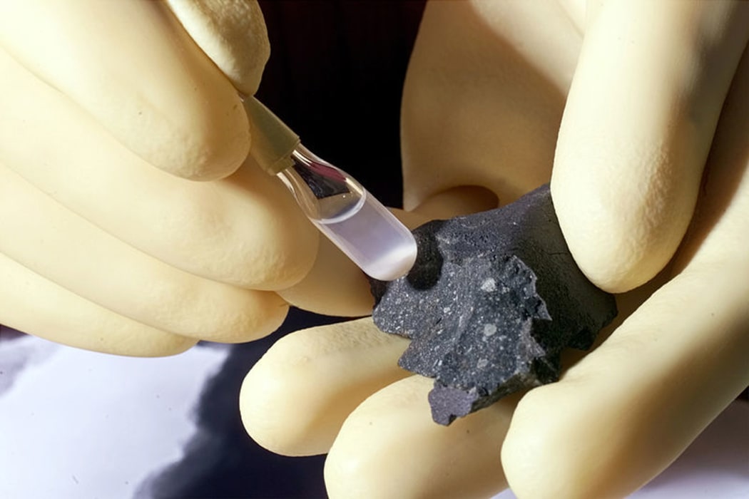 Fragment of the Murchison meteorite (at right) and isolated individual particles (shown in the test tube).