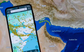 A map shows current air traffic across the Middle East on a laptop and smartphone in this photo illustration, as airlines reroute or cancel flights following escalating conflict involving Iran that leads to widespread airspace closures and major disruption to global aviation routes in Brussels, Belgium, on March 5, 2026. (Photo by Jonathan Raa/NurPhoto) (Photo by Jonathan Raa / NurPhoto via AFP)
