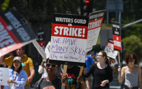 Hollywood writers and their supporters walk the picket line outside Universal Studios Hollywood in Los Angeles, California, June 30, 2023. Hollywood's summer of discontent could dramatically escalate this weekend, with actors ready to join writers in a massive "double strike" that would bring nearly all US film and television productions to a halt. The Screen Actors Guild (SAG-AFTRA) is locked in last-minute negotiations with the likes of Netflix and Disney, with the deadline fast approaching at midnight Friday (0700 GMT Saturday). (Photo by Robyn Beck / AFP)
