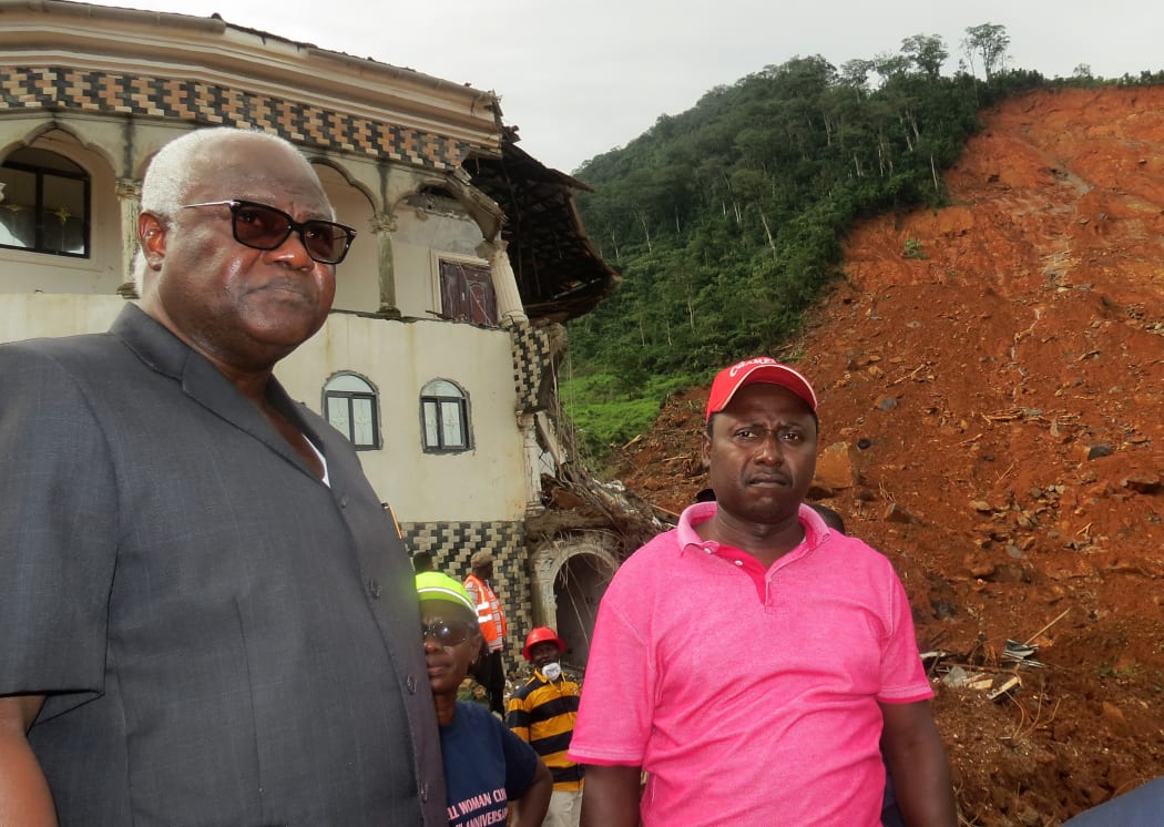 Sierra Leone president Ernest Bai Koroma, left, visits the site of a massive mudslide in Regent, near Freetown, on 15 August 2017.