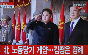 This screen grab taken from Yonhap News TV shows Kim Jong-Un (C) and Liu Yunshan (R).