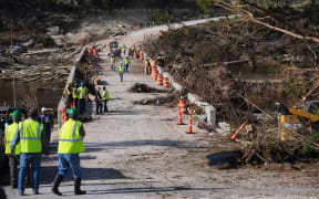 Crews work to clear debris July 10 on the Cade Loop Bridge after flooding along the Guadalupe River in Ingram, Texas.